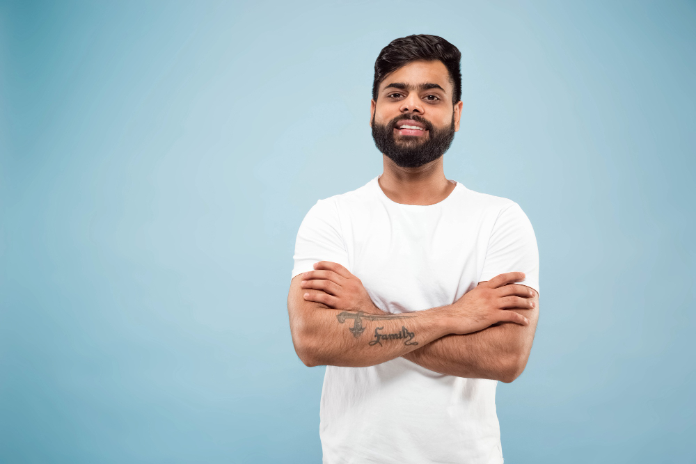 close up portrait young indian man white shirt posing standing smiling looks calm - Sresth ORA